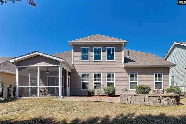 rear view of property featuring a lawn, fence, a sunroom, and a shingled roof