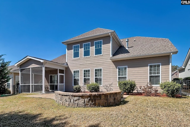 rear view of house with a lawn, a sunroom, and a shingled roof