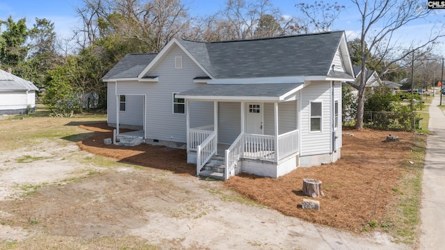 view of front of home with a porch, crawl space, roof with shingles, and dirt driveway