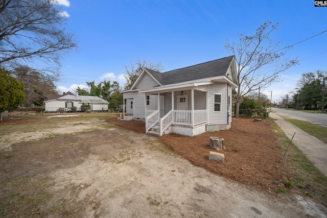 bungalow with covered porch, a shingled roof, and crawl space