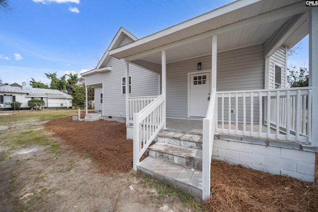 entrance to property featuring crawl space and covered porch