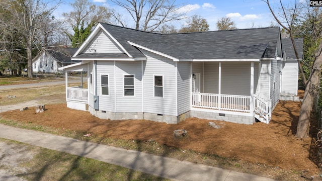 view of front of home featuring crawl space, covered porch, and roof with shingles