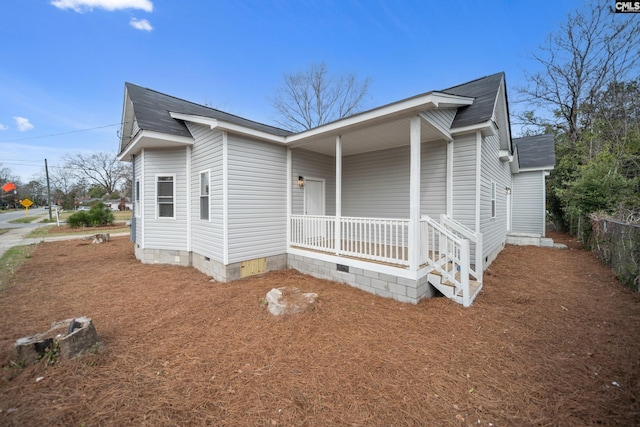 view of front facade with covered porch, a shingled roof, and crawl space