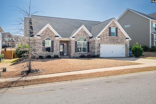 view of front facade with driveway, brick siding, roof with shingles, and an attached garage