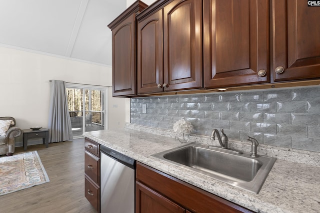 kitchen with decorative backsplash, dishwasher, light stone countertops, light wood-style floors, and a sink