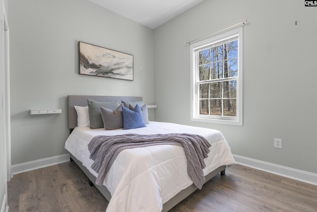 bedroom with baseboards and wood finished floors