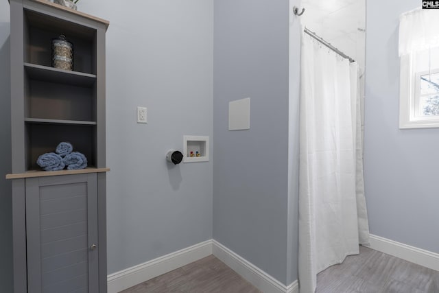 washroom featuring laundry area, washer hookup, wood finished floors, and baseboards