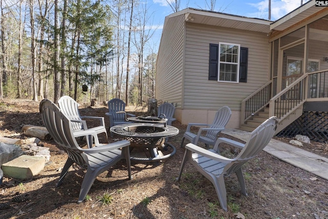 view of patio featuring a sunroom and a fire pit