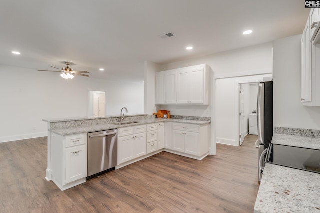 kitchen with visible vents, stainless steel dishwasher, white cabinets, a sink, and a peninsula