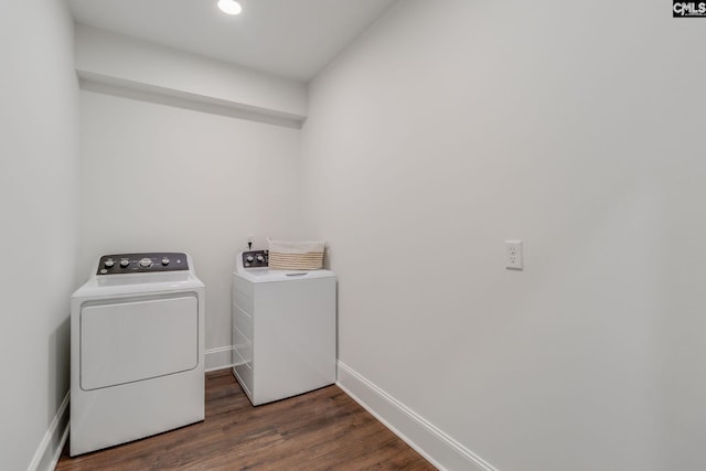 laundry area featuring dark wood-type flooring, laundry area, independent washer and dryer, and baseboards