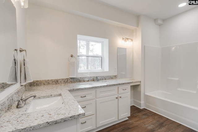 full bath featuring recessed lighting, shower / bath combination, vanity, and wood finished floors