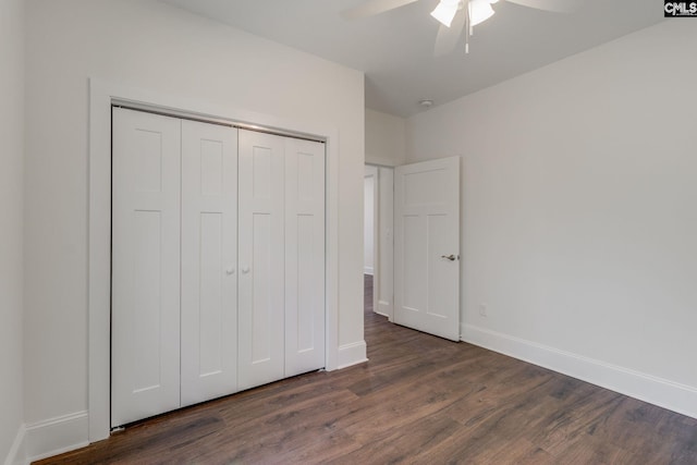 unfurnished bedroom featuring dark wood-type flooring, a closet, a ceiling fan, and baseboards