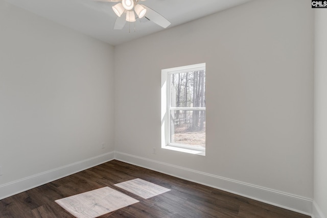 empty room featuring a ceiling fan, dark wood finished floors, and baseboards