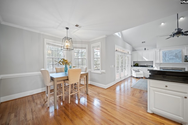 dining space with light wood-style floors, baseboards, visible vents, and crown molding