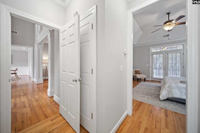 hall with ornate columns, baseboards, visible vents, and light wood-style floors