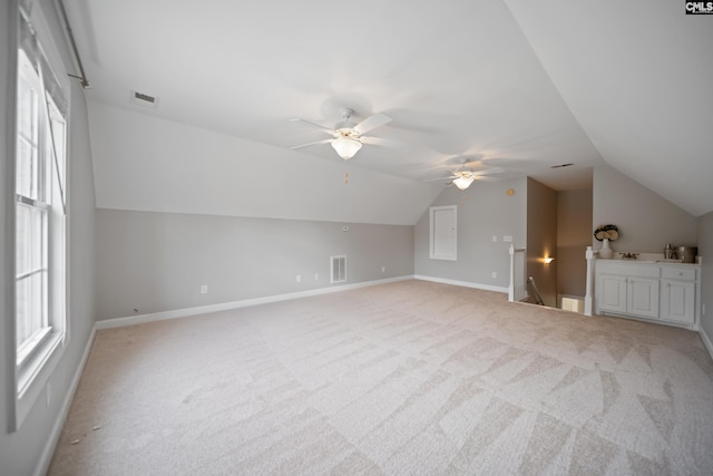 bonus room with visible vents, vaulted ceiling, and light carpet