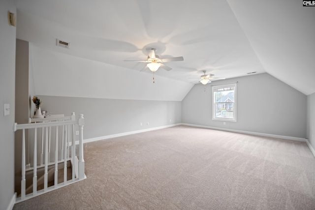 additional living space featuring carpet, visible vents, vaulted ceiling, and baseboards