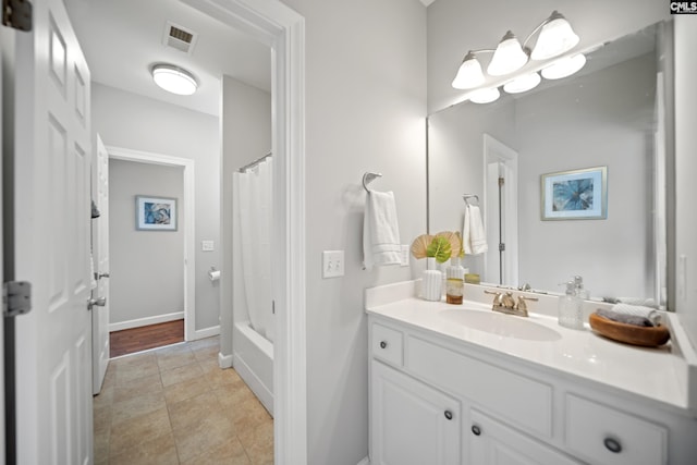 full bath with visible vents, shower / bath combo with shower curtain, vanity, baseboards, and tile patterned floors