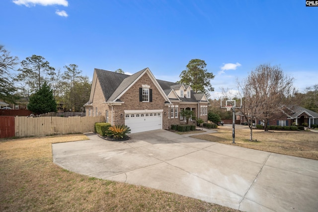 traditional home with brick siding, concrete driveway, a front yard, fence, and a garage