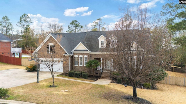 view of front of property featuring a garage, brick siding, concrete driveway, fence, and a front yard