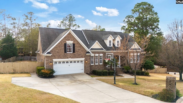 traditional-style home featuring brick siding, fence, concrete driveway, and a front yard