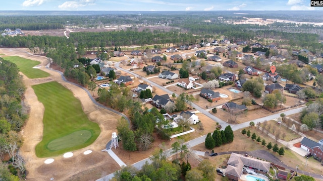 drone / aerial view with view of golf course and a view of trees