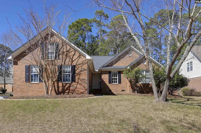 traditional-style home with a shingled roof, crawl space, brick siding, and a front lawn