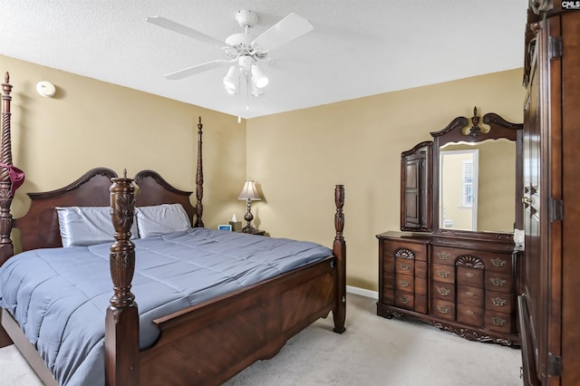 bedroom with a textured ceiling, a ceiling fan, and light colored carpet