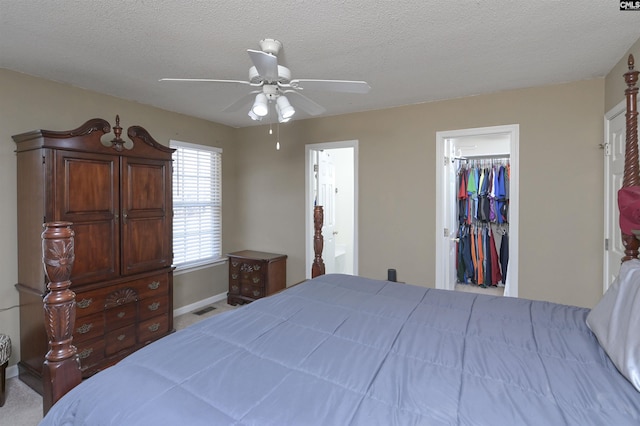 bedroom featuring visible vents, ceiling fan, a walk in closet, a textured ceiling, and a closet