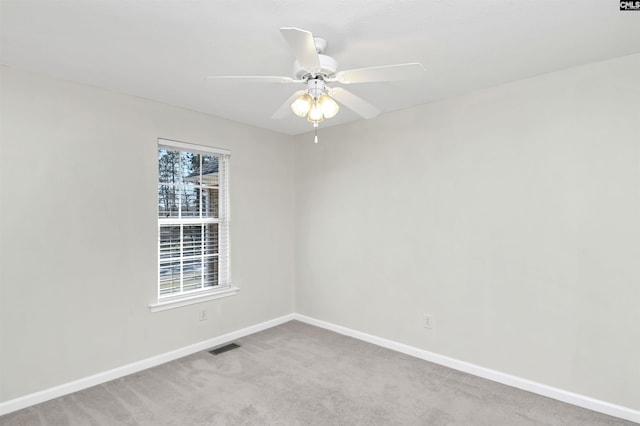 carpeted spare room featuring visible vents, ceiling fan, and baseboards