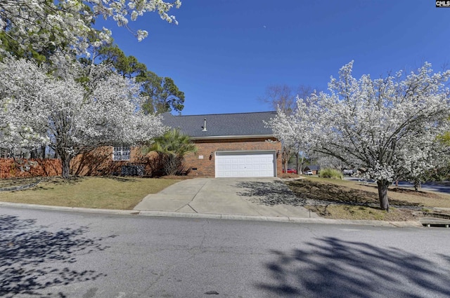 view of front of home with a garage, a front yard, concrete driveway, and brick siding