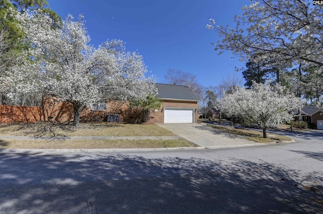 obstructed view of property with driveway, a garage, and brick siding