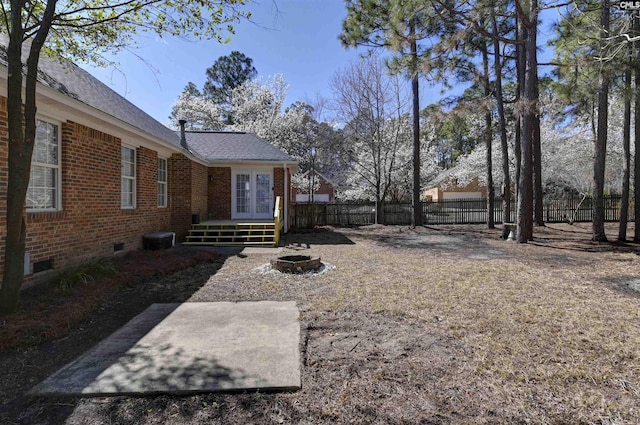 view of yard featuring an outdoor fire pit, fence, a wooden deck, and french doors