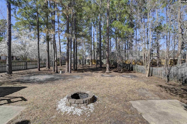 view of yard with an outdoor fire pit and fence