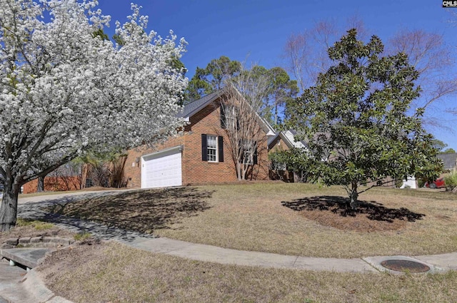 view of front facade with a garage, a front yard, and brick siding