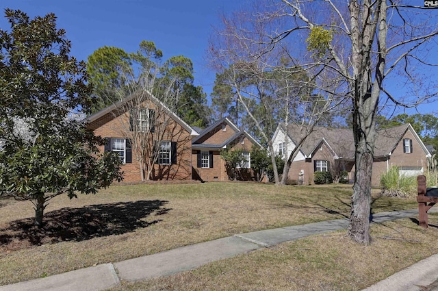 view of front of house with a front yard, crawl space, and brick siding