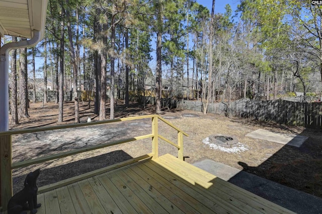 deck with a fire pit and fence