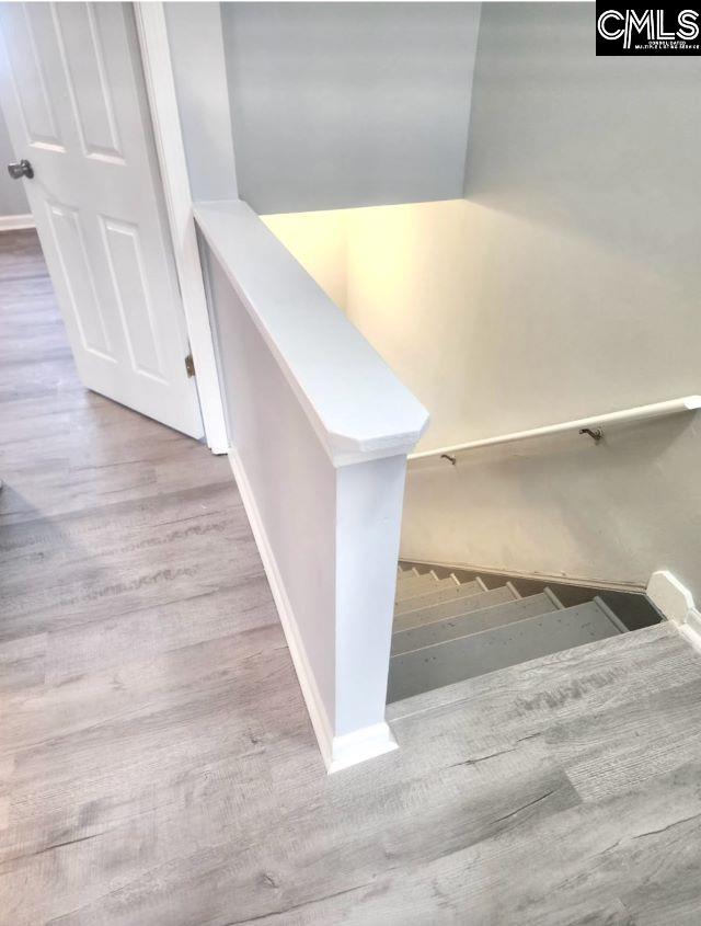 stairway with baseboards and wood finished floors