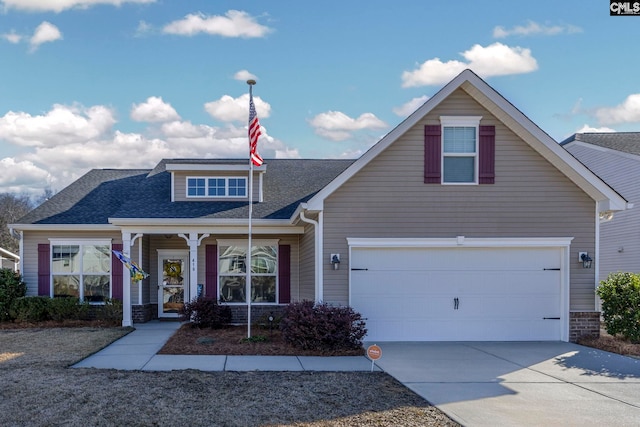 view of front facade featuring a garage, driveway, a shingled roof, and covered porch