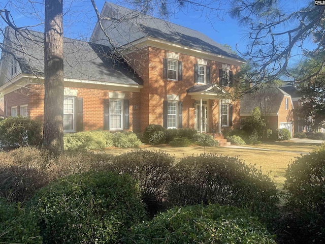 colonial-style house with brick siding