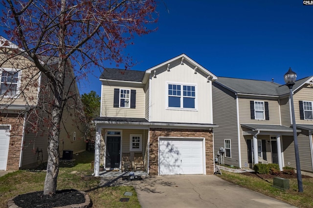 view of front of home with a porch, stone siding, driveway, and an attached garage