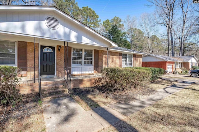 ranch-style house with covered porch and brick siding