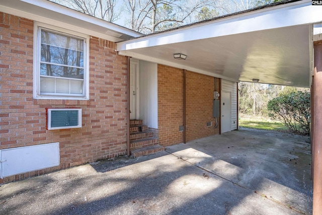 exterior space with a carport, entry steps, brick siding, and driveway