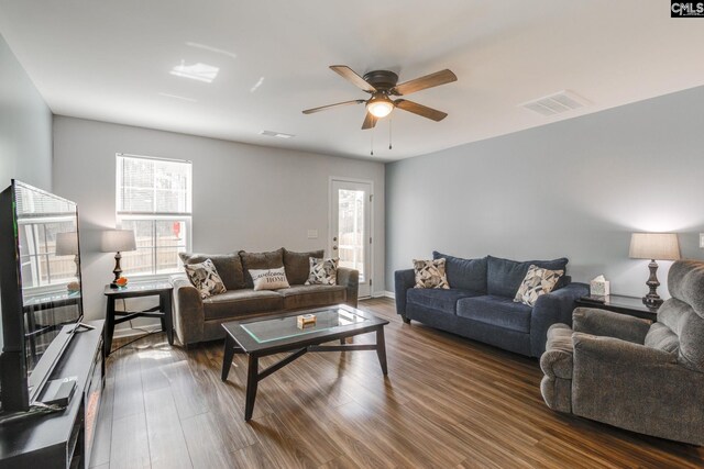 living area featuring dark wood-style floors, ceiling fan, and visible vents