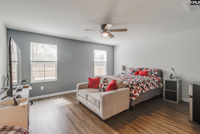 bedroom featuring a ceiling fan, visible vents, baseboards, and wood finished floors