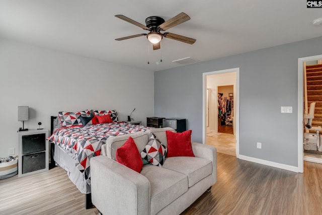 bedroom with baseboards, visible vents, ceiling fan, and wood finished floors