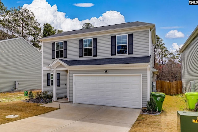 traditional home featuring driveway, a front lawn, an attached garage, and fence