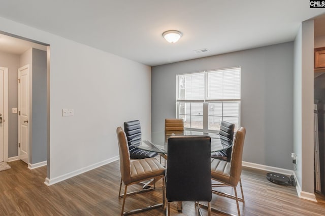 dining area featuring visible vents, light wood-style flooring, and baseboards