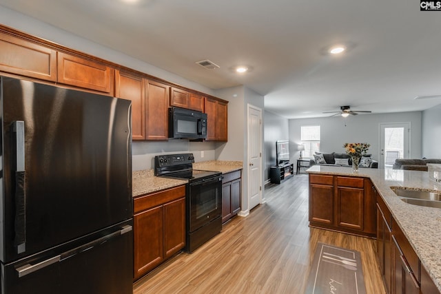 kitchen with visible vents, light wood-style floors, a ceiling fan, open floor plan, and black appliances