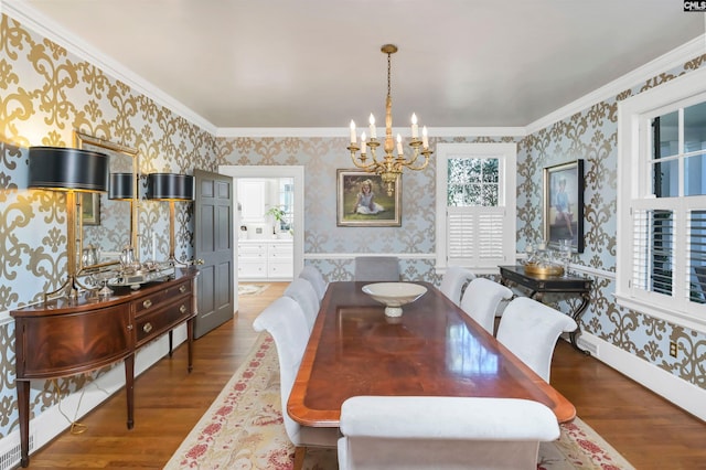 dining space featuring wallpapered walls, a notable chandelier, and wood finished floors